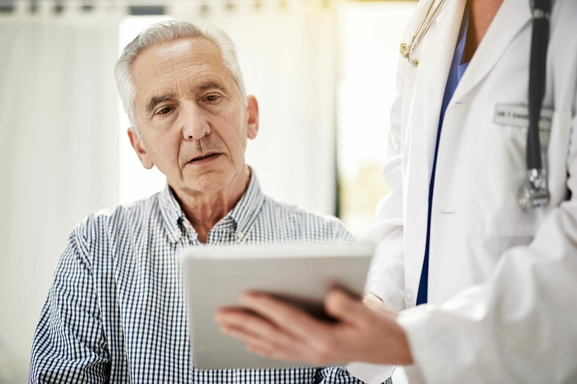 Senior with doctor reviewing information